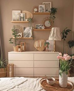 a white dresser topped with vases filled with flowers