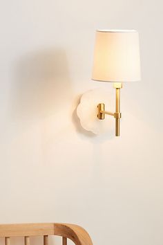 a lamp on the wall next to a crib with a bed in front of it