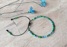 Adjustable shades of green and blue (Lagoon Color Mix) colored bracelet with a sliding closure! This one size bracelet is made with tiny 8/0 (3.1mm) Miyuki seed beads. It features shades of green and blue glass beads. The finish is macrame sliding knot on a black color high-quality Brazilian waxed cord. It may be tight at first but will become flexible over time. You can stack this bracelet with other bracelets or wear it alone. How to wear: Open the bracelet fully and slip over your hand, then pull the tail ends to your desired fit. ** This bracelet opens to about 10 inches to slip over your hand, then closes down to fit a wrist as small as 5.50 inches. ** Please message me if you are looking for a different size.  To maintain the quality of the stones and the bracelet keep them away from Green Beaded Bracelets With Adjustable Cord For Beach, Green Resizable Beaded Bracelets For Friendship, Green Resizable Friendship Bracelets With Round Beads, Green Adjustable Cord Friendship Bracelets For Beach, Green Adjustable Cord Bracelets For Beach, Green Beaded Bracelet With Adjustable Cord For Festival, Adjustable Green Friendship Bracelets, Green Beaded Bracelets With Adjustable Cord For Friendship, Adjustable Green Bracelets For Festival