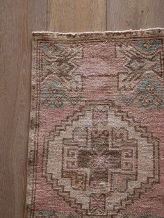 an old rug is laying on the floor in front of a wood flooring surface