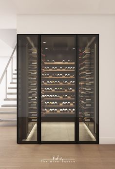 an empty wine cellar with many bottles in the wall and stairs leading up to it