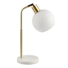 a white table lamp with a gold metal base and a round glass ball on top