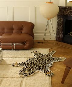 an animal print rug on the floor next to a couch and chair in a living room