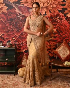 This authentic Layla saree is a one-of-a-kind attire that exudes glamour and modernity. The fishtail drape on the skirt adds a contemporary twist to your classic saree. The vivid embroidery details highlighted with beads are fascinating along with the attached sheer pallu. The sleeveless blouse is heavily accentuated with beads and sequins. A great show-stealer with a style so surreal. Heavily embellished cross-band sleeveless gold-foil printed blouse with centre back hook opening Fish-cut Saree with embroidered applique work with dabka and nakshi at the border of the pallu Side zip closure in the saree. From Moledro’s Riwayat collection. DELIVERY TIMEPlease allow 8-12 weeks for your outfit to arrive. FABRIC DETAILSSaree - Butterfly Net, Zari BrocadePallu - Butterfly NetBlouse - Cotton Sil Elegant Designer Pre-draped Saree With Resham Embroidery, Elegant Dola Silk Pre-draped Saree With Resham Embroidery, Floor-length Saree With Sheer Dupatta For Reception, Semi-stitched Pre-draped Saree With Sheer Dupatta For Diwali, Pre-draped Saree For Reception And Diwali, Bollywood Style Tissue Silk Pre-draped Saree For Designer Wear, Fitted Pre-draped Saree With Zari Work For Wedding, Fitted Bollywood Style Pre-draped Saree For Festive Occasions, Designer Pre-draped Dola Silk Saree With Dupatta