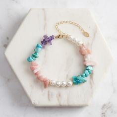 Step into a world of enchanting colors with our Dainty  Turquoise Pearl Bracelet , a delightful piece that brings together the serene hues of Turquoise, the ethereal glow of Shell Pearls, the soft radiance of Opal, and the regal touch of Amethyst.   Whether worn on a casual day out or as a unique statement piece for an evening event, this bracelet elevates your style with its playful yet refined aesthetic. Embrace the charm of this captivating piece and let it become a cherished part of your jewelry collection. DETAILS Plating: 14K Gold Materials: 925 Sterling Silver , Turquoise, Shell Pearl, Opal, Amethyst Stone: Turquoise(5-9mm/0.20"-0.35"), Shell Pearl(6mm/0.24"), Opal(5-8mm/0.2"-0.31"), Amethyst(5-8mm/0.2"-0.31") Measurements: Length: 6.50"(16.5cm) + Extender: 1.97"(5.0cm) Weight: 10.7 Gemstone Chips Bracelet, Silver Pearl Bracelet, Fruit Jewelry, Amethyst Bracelet, Feather Necklaces, Gold Bracelet Chain, Rose Gold Jewelry, Amethyst Stone, Rose Gold Earrings