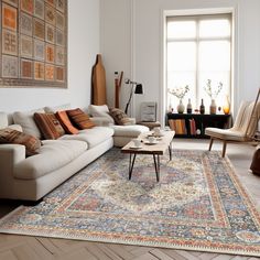 a living room filled with furniture and a large rug on top of a hard wood floor