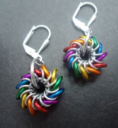 These little guys are called Whirlybirds. They are only 1/2 an inch wide and are made with lightweight aluminum rings in rainbow colors. They dangle from Stainless Steel leverback earwires.  If you're interested in a different color combination, let me know!  *Sterling Silver leverbacks are available for $6 more, please contact me before purchase! Chain Mail Earrings, Chainmaille Jewelry Patterns, Chainmaille Earrings, Jump Ring Jewelry, Chainmail Jewelry, Dragon Scales, Chainmaille Bracelet, Chain Maille Jewelry, Rainbow Jewelry