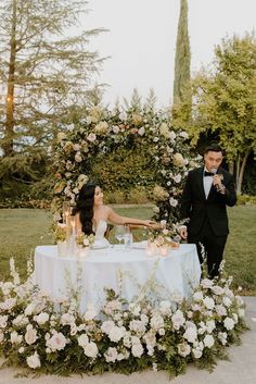 a man and woman sitting at a table with flowers