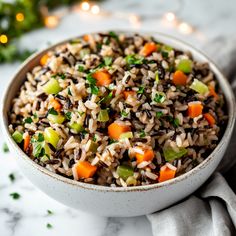 a bowl filled with rice and vegetables on top of a white countertop next to a christmas tree