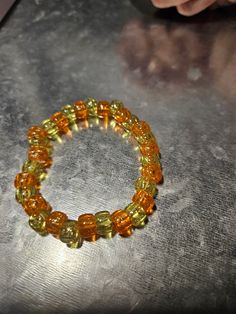 This orange and green beaded bracelet is fun for everyone! Great for parties, concerts and more! Yellow Beaded Bracelet For Party, Casual Yellow Bracelets With Letter Beads, Adjustable Yellow Beaded Bracelet For Parties, Party Bracelets With Colorful Beads In Yellow, Yellow Beaded Stretch Bracelet With Round Beads, Yellow Beaded Stretch Bracelet, Casual Green Stretch Bracelet With Spacer Beads, Casual Green Stretch Bracelet With Large Beads, Casual Gold Beaded Bracelets For Party