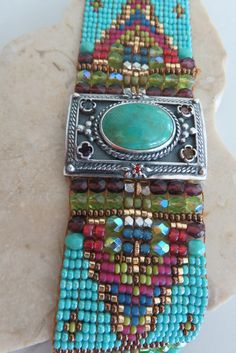 Chili Rose Beaded Turquoise & Gemstone Bracelet by Adonnah Langer of Santa Fe, New Mexico Gorgeous Diana Bracelet features a Southwestern blend of turquoise, olive green and red Swarovski beads handcrafted with a true artistic mix of beads and a canvas of gorgeous colors. Center Medallion features an array of semi-precious stones *Medallion measures 1 1/4 inch x 7/8 inch Santa Fe Jewelry Artist, Adonnah Langer has been designing distinctive wearable art for over two decades Stripes of Czech