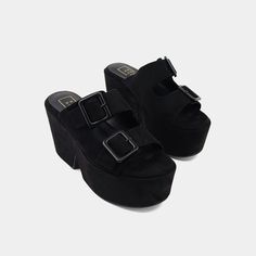 This striking black wedge platform sandal is crafted from luxurious suede and faux leather, offering both style and sophistication. The double buckle straps add an edgy flair, while the molded footbed guarantees unmatched comfort. With its bold platform, this sandal is designed to make a statement, ensuring you stand out effortlessly while enjoying all-day wear. Black Wedge, Black Wedge Sandals, Loafer Mules, Graceland, The Double, Sneaker Heels, Boot Sandals, Platform Wedges, Mule Clogs