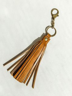 Leather fringe tassel with brass colored clip on a white background. Purse Tassels, Leather Tassel Keychain, Diy Leather Projects, Leather Making, Making Stuff, Purse Backpack, Leather Decor, Tassel Keychain, Chic Gifts