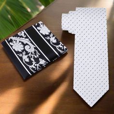 This classic silk necktie features a timeless pattern of small black dots on a crisp white background. The minimalist design offers a sophisticated and versatile accessory that can seamlessly transition from business to social settings. The high-quality silk fabric provides a smooth texture and a subtle sheen, making this tie an essential addition to any formal wardrobe. Dress Shirts White Dress Shirt: A white dress shirt creates a clean and monochromatic look, allowing the small black dots to s Elegant Polka Dot Ties, Classic Polka Dot Ties For Business, White Pocket Square For Business Suit, White Pocket Square For Black Tie Events, White Pocket Square For Business Suit Accessories, Formal Polka Dot Standard Tie, White Ties For Black Tie Events, Polka Dot Standard Tie For Formal Occasions, Elegant White Tie With Pocket Square