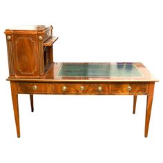 an antique desk with glass top and drawers