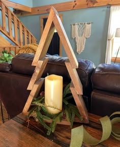 a candle sits in front of a wooden triangle