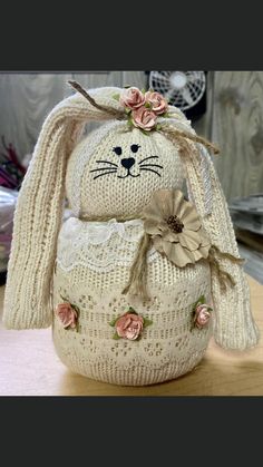 a knitted bunny sitting on top of a wooden table