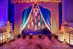 an elaborate stage set up for a wedding with blue curtains and lights on the side