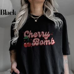 Cherry Bomb Shirt - Explode with Retro Flair! Embrace your playful side with this vibrant Cherry Bomb Shirt, designed for anyone who loves a touch of coquette charm and Y2K nostalgia. Perfect for making a statement, this graphic baby tee features a bold cherry design that adds a retro twist to any outfit. Ideal for a fun day out or as a stylish everyday piece. All clothing and accessories from The Southern Thistle are handmade-to-order, just for you! ☺️  SIZING: Tshirts and sweatshirts are unisex, classic fit. Please refer to size chart in listing photos for details. Easy measuring tip: Take your favorite shirt, lay it on a flat surface and measure the width (armpit to armpit) and length (top to bottom) Shirts are pre-shrunk but may shrink slightly after washing. CARE INSTRUCTIONS:  For lo Cherry Shirt, Retro Cherry, Y2k Nostalgia, Coquette Shirt, Cherry Design, Shirt Coquette, Graphic Baby Tee, Baby Graphic Tees, Aesthetic Y2k