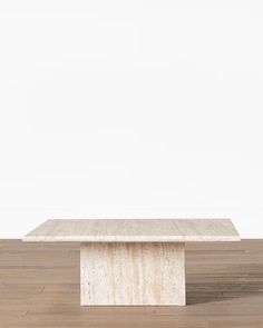 a white table sitting on top of a hard wood floor next to a white wall