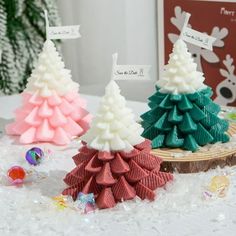 three small christmas trees sitting on top of a table