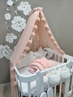 a baby crib with pink and white flowers on the wall