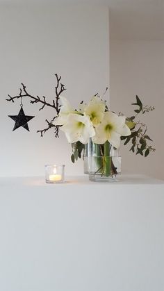 a vase filled with white flowers next to a candle