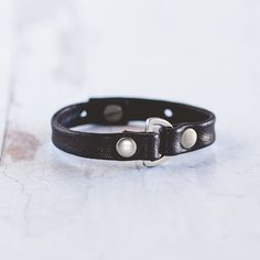 Our Do Good Bracelet is handcrafted with the softest lamb leather and detailed with a rounded D-ring and large flat rivets. This bracelet can be worn alone or stacked with your favorite Giving Bracelet! FEATURES Handcrafted - Each Bracelet is delicately handcrafted. Finest Leather Available - We use lamb leather to achieve a much softer feel than cow leather. Makes The World a Better Place - The heart of our business is giving back and we are honored to be partnered with Voices for CASA Children Adjustable Cuff Leather Bracelet For Everyday, Adjustable Leather Cuff Bracelet For Everyday, Adjustable Leather Bracelet With Snap Closure, Classic Adjustable Leather Bracelet With Wrist Strap, Adjustable Black Band Cuff Bracelet For Everyday, Adjustable Classic Bracelet, Adjustable Black Leather Cuff Bracelet, Adjustable Cuff Bracelet With Wrist Strap For Everyday, Adjustable Wrist Strap Cuff Bracelet For Everyday