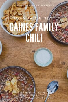 three bowls filled with beans and chips on top of a wooden table