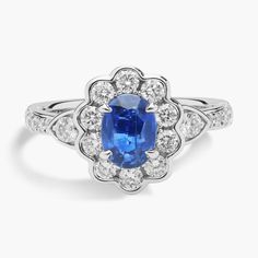 an oval shaped blue sapphire and diamond ring in 18k white gold with diamonds surrounding it