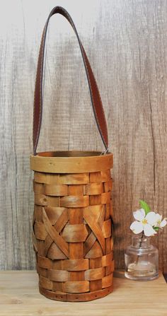 a wooden basket sitting on top of a table next to a vase