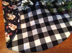 two vases with flowers sitting on top of a black and white checkered table cloth