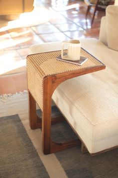 a coffee table with a cup on it in the middle of a living room area