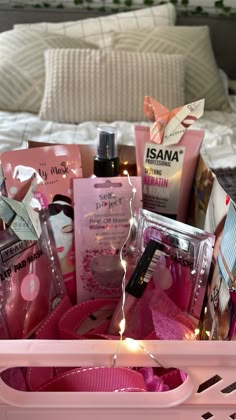 a pink basket filled with personal care items on top of a bed next to a night stand