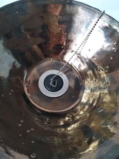 a close up of a metal disk with a clock on it's center piece