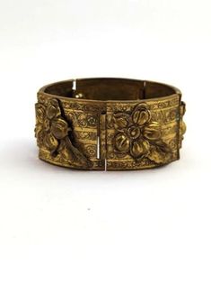 Vintage MCM bracelet in brass with flowers and leaf design. 1960's. The bracelet is in good vintage condition. Measures about 7 inches and about 1 1/4 inches wide. Please visit our Etsy store for similar items at http://www.etsy.com/shop/MarleysOnMain As with all vintage and antique jewelry, this is a previously used piece and will show some signs of wear. Please review our shop policies.Jewelry Vintage jewelry Vintage Gold Bracelets For Ceremonial Occasions, Vintage Antique Gold Bracelets For Formal Occasions, Antique Gold Vintage Bracelet For Formal Occasions, Antique Gold Brass Bracelets For Formal Occasions, Formal Antique Gold Brass Bracelets, Formal Antique Gold Brass Bracelet, Vintage Brass Bangle For Gift, Vintage Bronze Bracelets For Wedding, Vintage Bronze Cuff Bracelet For Formal Events