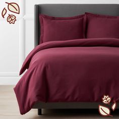 a bed covered in maroon sheets and pillows