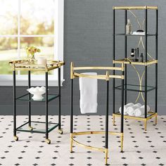 two black and gold bathroom shelvings with white towels