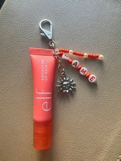 an orange tube and keychain on a table