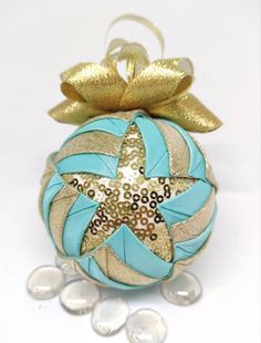 a christmas ornament with a starfish on it's side and gold ribbon