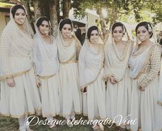 a group of women standing next to each other wearing white dresses and head coverings