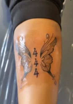 a woman's leg with butterflies and numbers on it