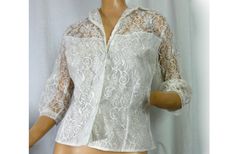 "Lovely lavish lace off white lace blouse/ jacket.  Has that rich Victorian revival style. Perfect for evening wear or wedding. Romantic Gunne Sax look. NOS never worn with store tags attached. Exquisite!  - off white floral and swirl pattern lace - modesty lining at the lower part, sheer shoulders and back - large round covered button and one small clear button at the front - sheer lace sleeves with narrow cuffs - princess fitting seams for body hugging fit - label - A Capri Original - size 36 Formal Scalloped Lace For Spring, Elegant Fitted Lace For Formal Occasions, Formal Long Sleeve Blouse With Scalloped Lace, Spring Wedding Lace With Lace Collar, Formal Fitted Blouse With Scalloped Lace, Formal Spring Blouse With Scalloped Lace, Formal Long Sleeve Tops With Scalloped Lace, Formal Scalloped Lace Top, Elegant Lace Top With Lace Cuffs