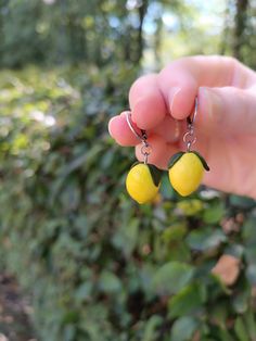 Brighten up your look with these delightful Lemon Earrings! Handcrafted from high-quality polymer clay, these charming lemon earrings add a fresh and fun touch to any outfit.  Perfect for summer days, tropical vacations, or simply bringing a splash of sunshine to your everyday style. These lemon earrings feature a realistic and vibrant design, capturing the essence of fresh lemons in a playful and stylish way.  Made from durable and lightweight polymer clay, these earrings are hypoallergenic. These earrings are very lightweight and won't feel heavy on your earlobe, ensuring all-day comfort.  The earring hooks are made from nickel-free and lead-free metal, making them safe and comfortable for sensitive ears.  size classic english ring - 12 mm / surgical steel  size lemon 1,7 cm. These earri Yellow Fruit Design Earrings For Gift, Yellow Fruit Design Earrings Gift, Yellow Fruit Design Earrings As Gift, Handmade Lemon Color Dangle Jewelry, Lemon Earrings, Earrings Food, Tropical Vacations, Food Earrings, Fruit Earrings