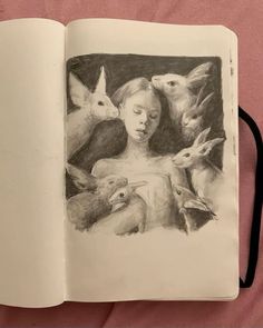 an open book with drawings of animals and a woman's face in the middle