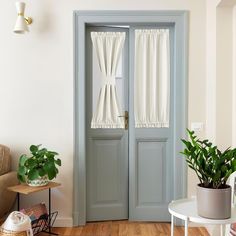 a living room with two doors and some plants