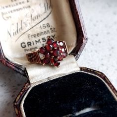 This elegant antique style gold and garnet ring would make a wonderful gift for that special someone. Set in 9 ct solid rosey yellow gold featuring 13 deep red natural garnets in a flower design. Fully British Hallmarked. INTERNATIONAL BUYERS - please read the shipping information below. Follow us on Instagram for all our latest pieces and first Dibs! They don't all make it to our Etsy store: https://www.instagram.com/mooreperfectpieces/ Fully British Hallmarked - 375 hallmark,  denoting solid 9 Antique Gemstone Cluster Ring For Anniversary, Vintage Garnet Birthstone Ring In Yellow Gold, Vintage Yellow Gold Garnet Birthstone Ring, Vintage Garnet Birthstone Rings, Vintage Garnet Birthstone Promise Ring, Antique Garnet Promise Ring, Vintage Garnet Cluster Ring With Gemstone, Antique Cluster Ring With Gemstone For Gift, Antique Gemstone Cluster Ring As Gift