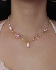 The Lily Charm Choker Necklace is a dainty necklace featuring a radiant chain with round links and five pastel-colored charms including two iridescent rectangle connectors, one butterfly connector, one flower connector, and one iridescent rectangle charm at the center.  * Length: 14.25" inches + 3" extender  * 24k & 14k gold-filled brass; cubic zirconia  * Waterproof & sweat-proof  * Handmade & made-to-order See our Jewelry Care guide. Chokers Necklace, Pastel Jewelry, Charm Choker Necklace, One Flower, Waterproof Jewelry, Sweat Proof, Jewelry Inspo, Dream Jewelry, Simple Jewelry