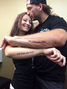 two people hugging each other with tattoos on their arms