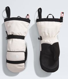 the north face white and black mittens are shown in front of a gray background